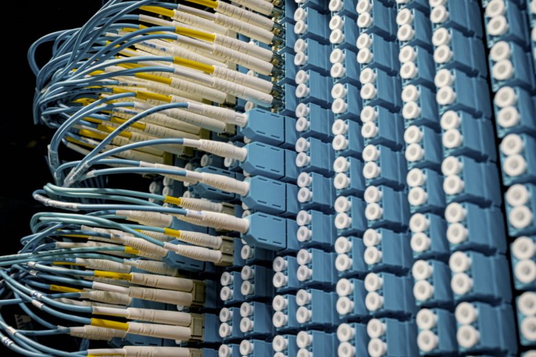 Rows of multiple fiber optic cables plugged into different ports. 